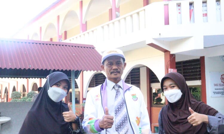 DUTA SEKOLAH: Dari kiri, Nurul Isnina, Kepala SMK PK Islamic Village Karawaci Mukhasin, dan Sunarti berfoto di sekolah.