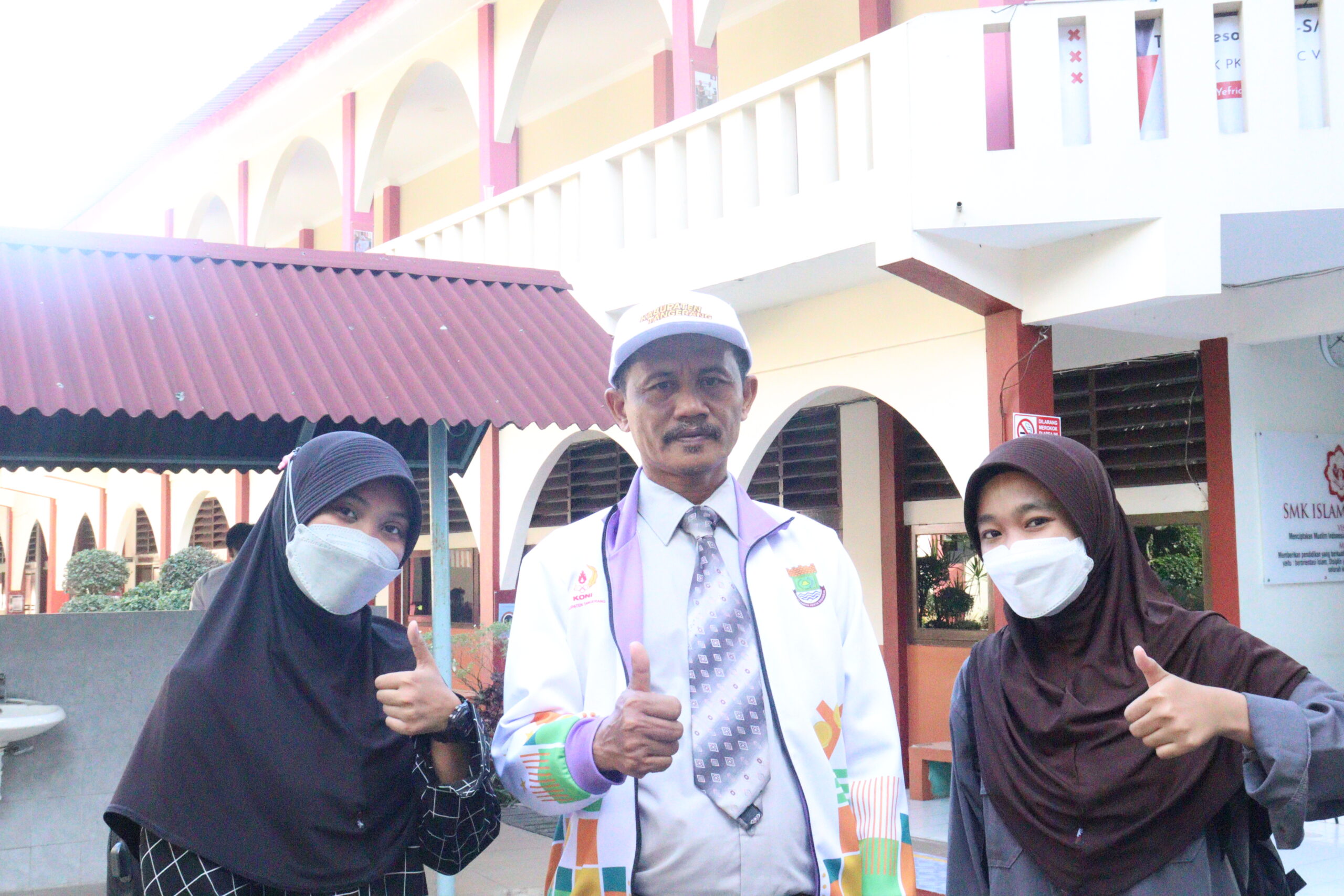 DUTA SEKOLAH: Dari kiri, Nurul Isnina, Kepala SMK PK Islamic Village Karawaci Mukhasin, dan Sunarti berfoto di sekolah.